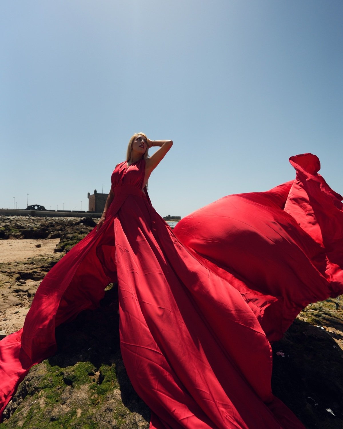 Paris red flying dress beside the Atlantic Ocean in Essaouira